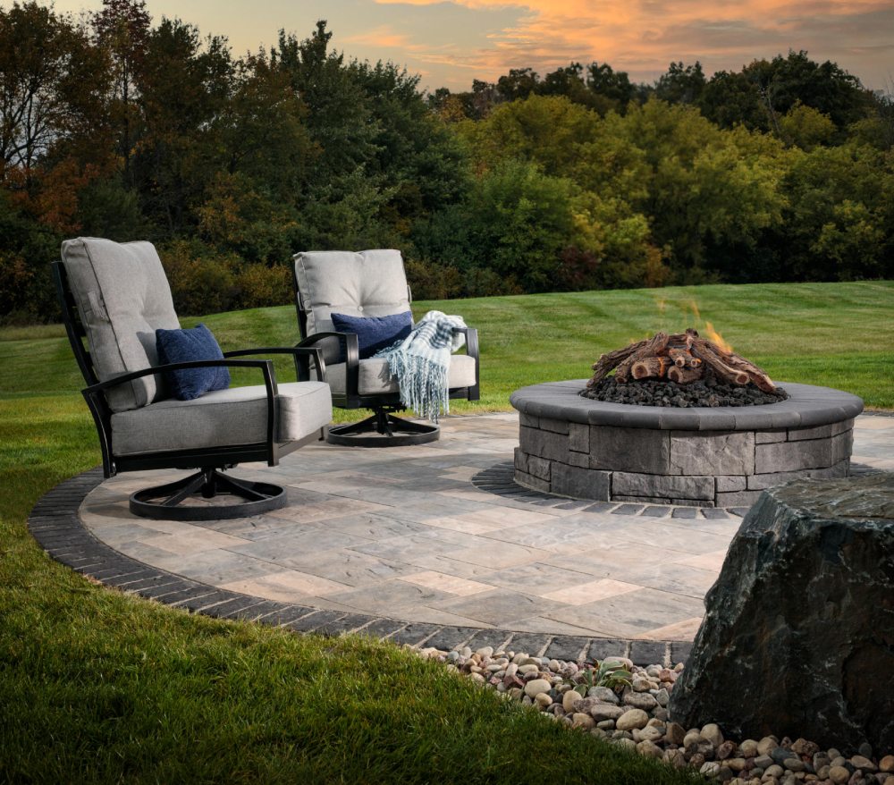 wood burning firepit with white cushioned chairs and blue pillows