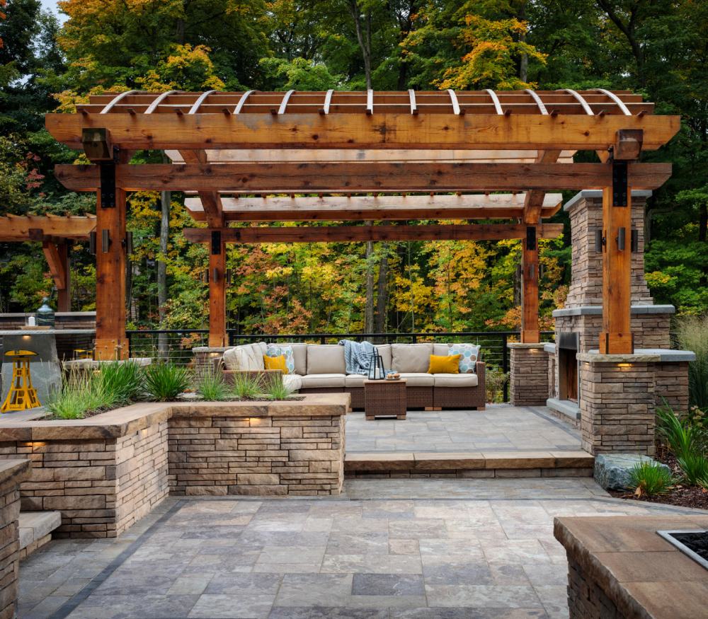 brown cushioned couch in paved area and brown wooden pergola