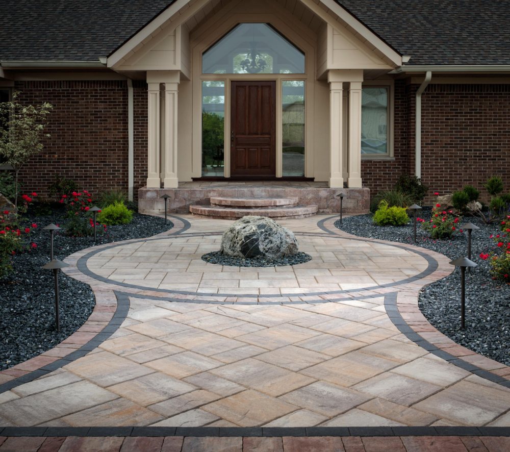 beige paved walkway with brick house and brown door