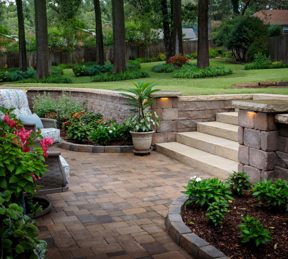 brown paved walkway with gray chairs and green plants