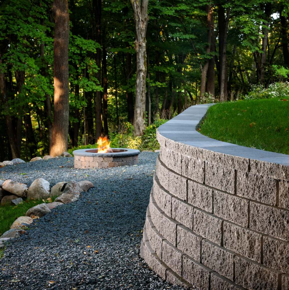 firepit with trees and stone wall