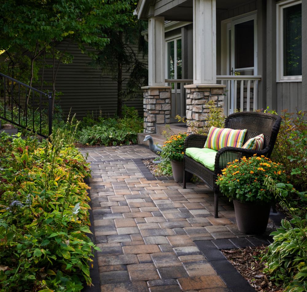 paved walkway with brown chair and striped pillow